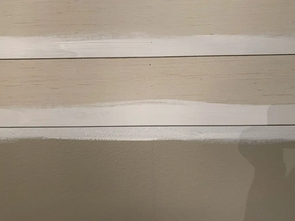 Partial install of shiplap with paint between the boards.